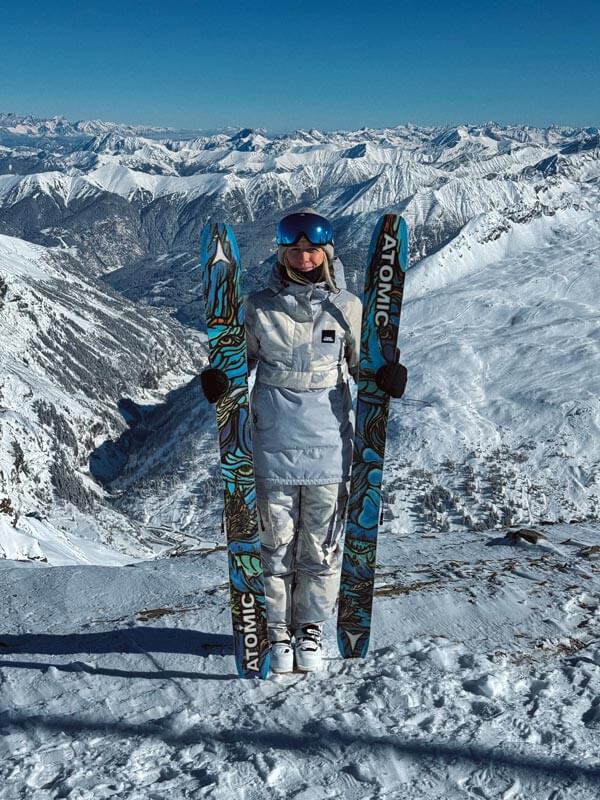 Skifahrerin mit Skiern und Blick auf die Berge