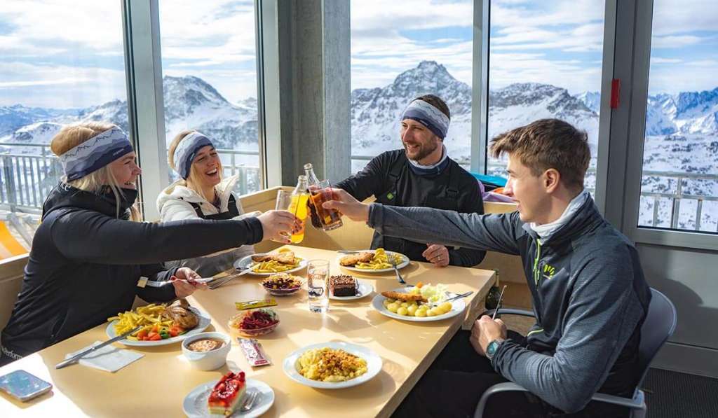 Gruppe von Menschen beim Mittagessen in einem Bergrestaurant