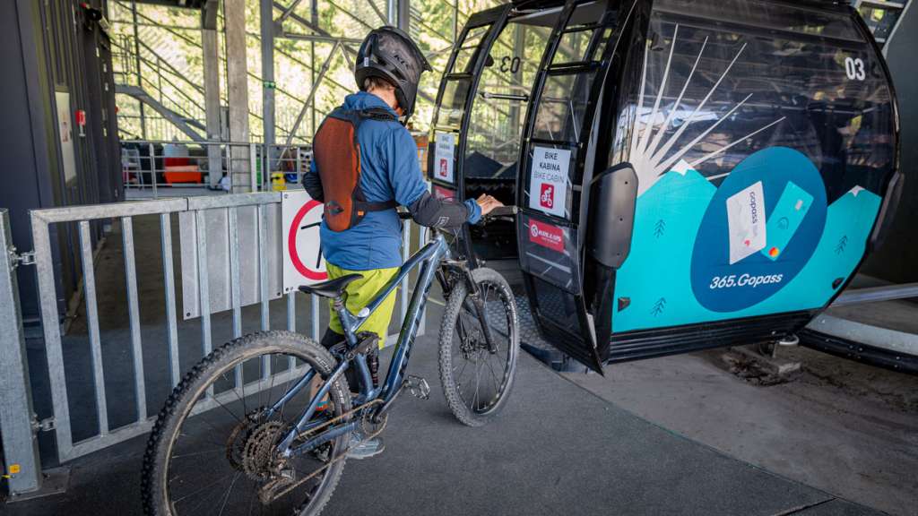Cyclist boarding a bike gondola with a full-suspension bike at Bike Park Jasná