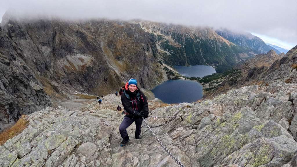 A hiker using chains to descend towards the Polish side of Rysy