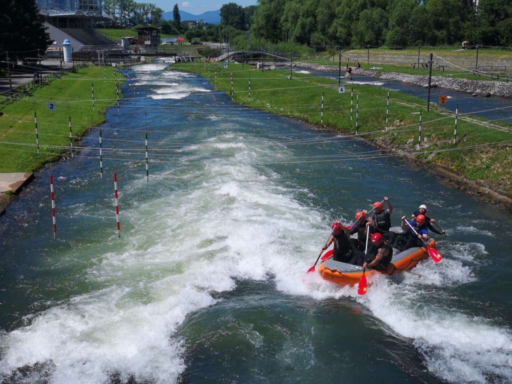A group of people on a raft at the Liptovský Mikuláš white-water slalom course