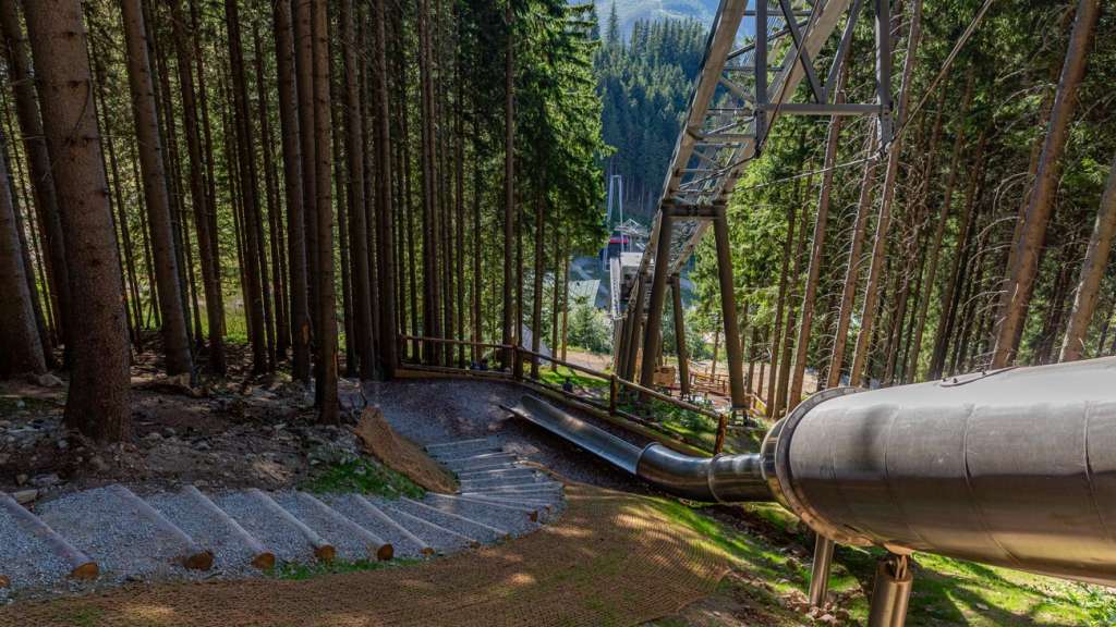 Stainless-steel forest slide winding through the trees