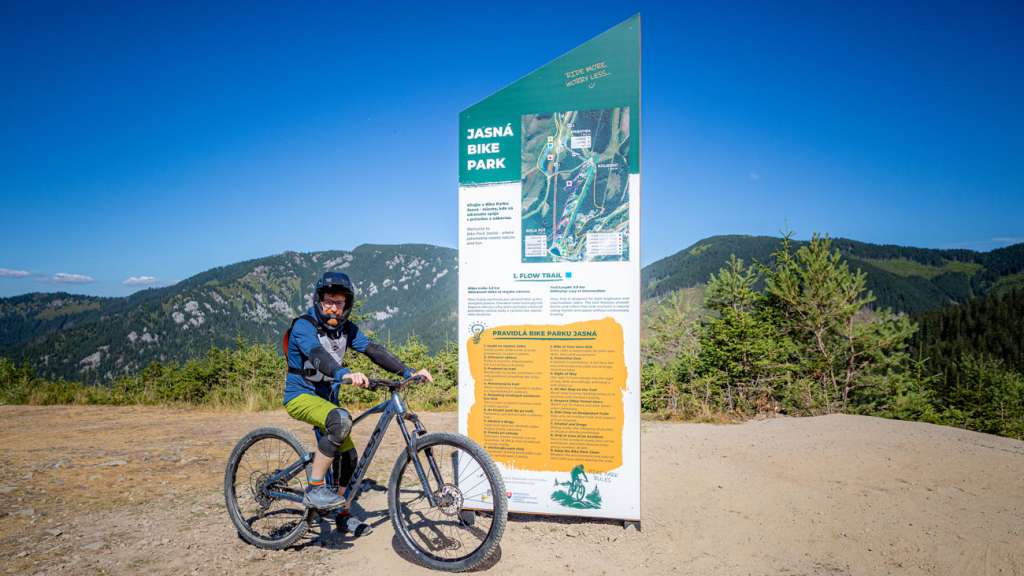 Mountain biker with a Kellys bike by the Jasná Bike Park information board